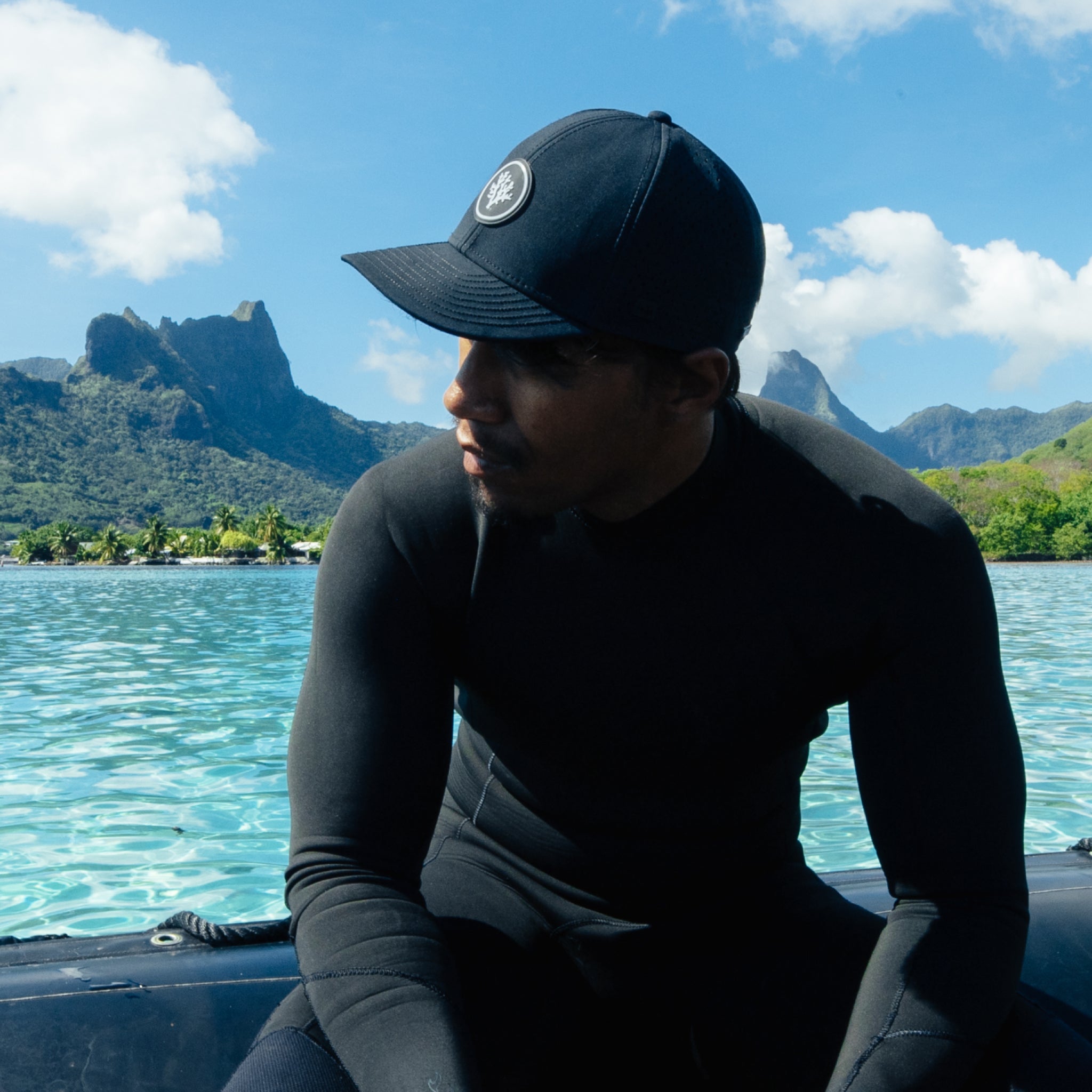 A man wearing the melin A-Game Coral Gardeners Hydro on a boat