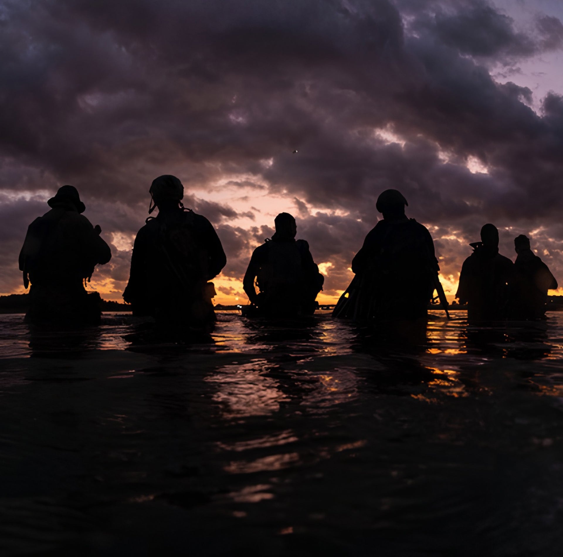 Silhouettes of first responders in the water against a dramatic sky during sunset or sunrise with text about melin Give- Back initiatives