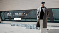 Person wearing a long coat and cap standing in front of a modern building with 'Melin Thermal' branding.