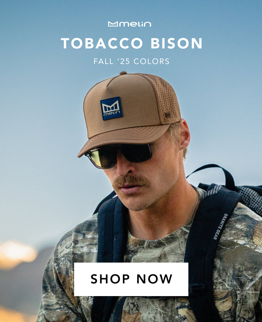 Man wearing the melin Odysea Stacked Hydro, sunglasses, and camouflage jacket against a blue sky.
