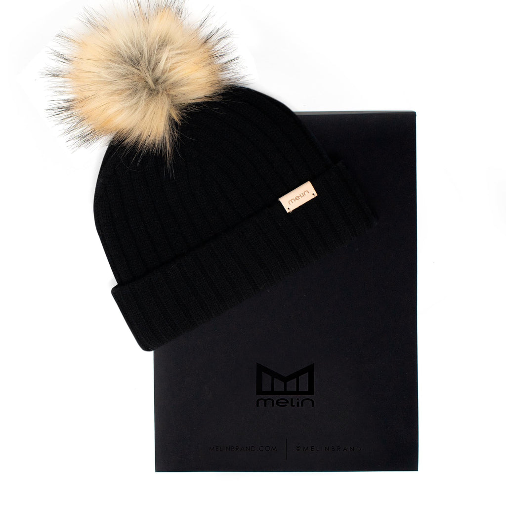 The frontal view of the Melin All-Day Pom Beanie in black next to packaging Big Image - 5